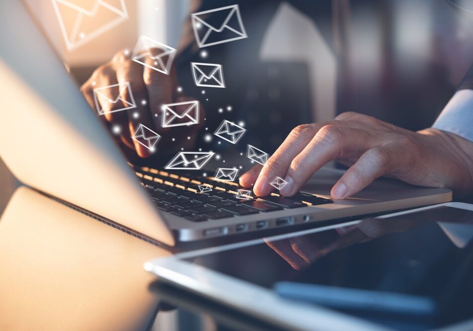 Close up of business man working on laptop computer, sending email