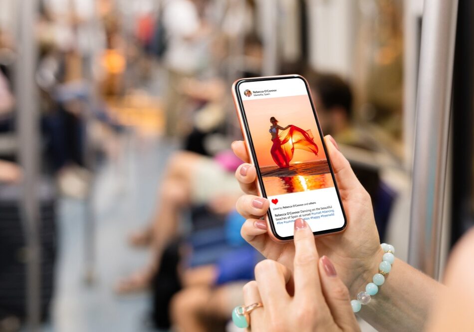 Woman,Riding,In,Metro,And,Viewing,Someone's,Photo,On,Mobile Woman riding in metro and viewing someone's photo on mobile phone
