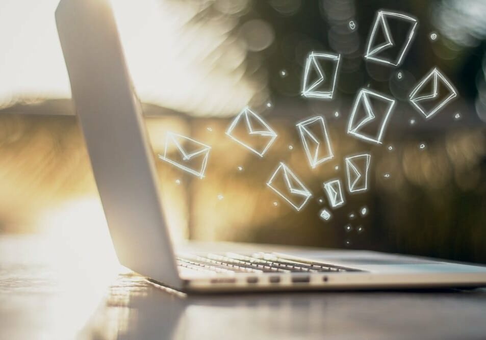 Side view of laptop with e-mail icons