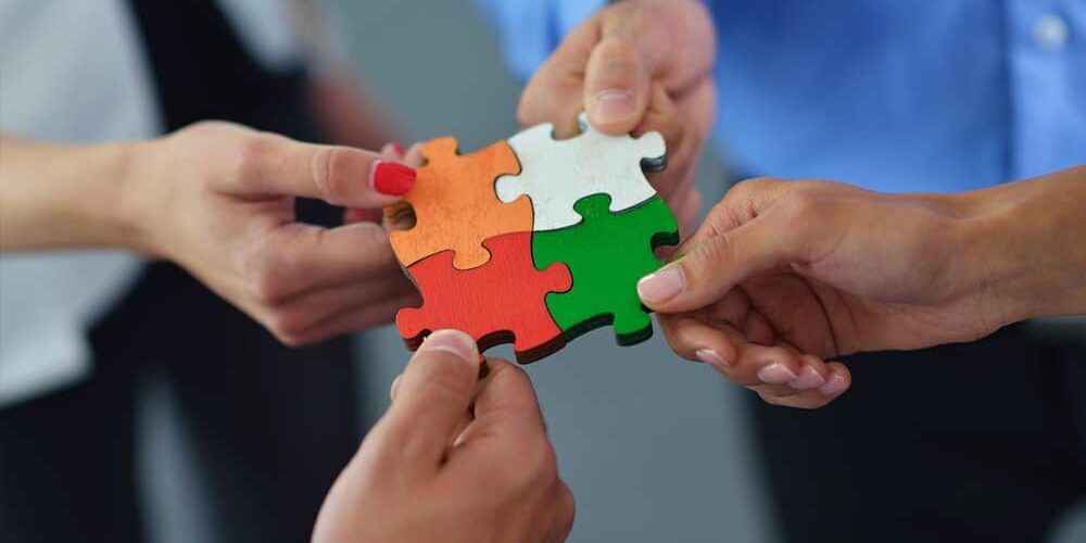 Team holding puzzle pieces together