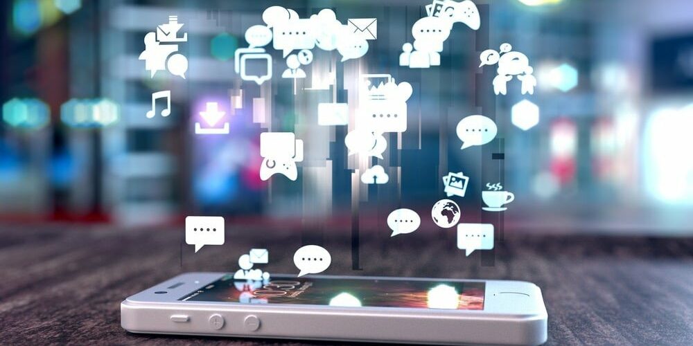 White smart phone with holographic image of social media